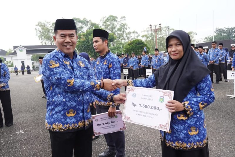 Penjabat Sekda Kabupaten Tebo, Dr. Sindi, S.H., M.H., menyerahkan santunan sebesar Rp1.500.000,- dari Dewan Pengurus KORPRI Kabupaten Tebo kepada ASN aktif dalam rangka peringatan Hari Kesadaran Nasional dan Harganas ke-32, Kamis (17/7/2025) di Lapangan Kantor Bupati Tebo.(INJ/Ist)