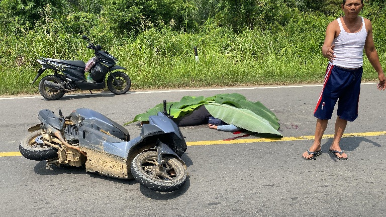 Lokasi kecelakaan tabrak lari di jalan KM 16 arah Desa Kandang, Kabupaten Tebo. Terlihat korban tergeletak di tengah jalan dan sudah ditutupi daun pisang, sementara sepeda motor korban mengalami kerusakan parah.(INJ/Ist)