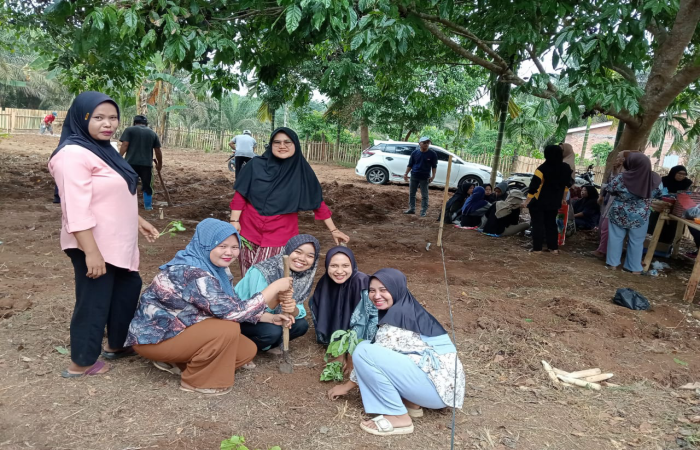 Sejumlah ibu-ibu dari PKK Desa Mengupeh bersama mahasiswa Kukerta Posko VIII sedang melakukan penanaman tanaman toga (tanaman obat keluarga) di halaman depan kantor desa.(INJ/Ist)